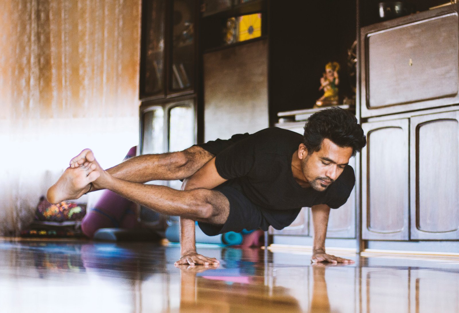 man doing yoga balancing on two hands