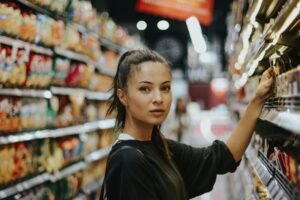 Woman picking something off a gondola shelf